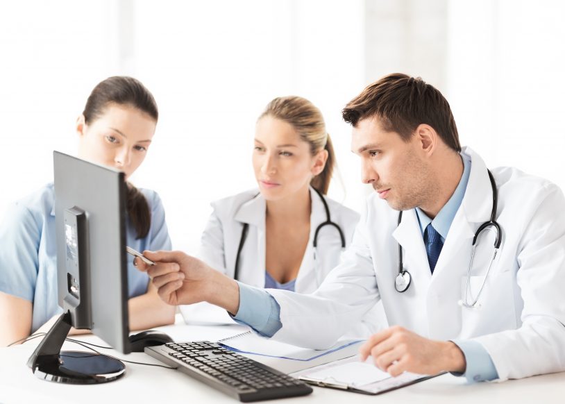 doctors and nurse looking at computer screen